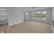 Open-concept living room featuring large windows, recessed lighting, and luxury vinyl plank flooring at 1709 Real St, Indianapolis, IN 46240