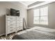 Bright bedroom with a large window, dresser, TV, and comfortable bed at 19629 Astoria Ave, Sheridan, IN 46069