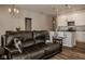 Spacious living room with leather reclining sofa and view into kitchen at 19629 Astoria Ave, Sheridan, IN 46069