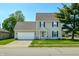 Charming two-story home with attached two car garage, a well-maintained lawn and colorful flowerbeds at 2062 Sumpter Trl, Columbus, IN 47203