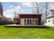 Modern home featuring floor-to-ceiling windows, a wooden deck, and a spacious green lawn at 2894 W Grove Dr, Greenfield, IN 46140