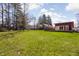 Expansive backyard featuring mature trees, lush grass, and a contemporary home with a large deck at 2894 W Grove Dr, Greenfield, IN 46140
