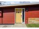 Close-up of a vibrant yellow front door with a modern design, set against a red-paneled exterior at 2894 W Grove Dr, Greenfield, IN 46140