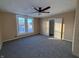 Spacious bedroom with ceiling fan, grey carpet, and ample sunlight at 325 S Market St, Thorntown, IN 46071