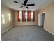 Large bedroom with ceiling fan, grey carpet and window with curtains at 325 S Market St, Thorntown, IN 46071