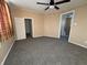 Spacious bedroom with ceiling fan, grey carpet, and access to upper level at 325 S Market St, Thorntown, IN 46071