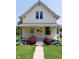 Charming two-story home with inviting front porch adorned with lush red roses and greenery at 325 S Market St, Thorntown, IN 46071