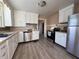 Bright kitchen features white cabinets, stainless steel appliances, and wood-look flooring at 325 S Market St, Thorntown, IN 46071