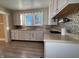Kitchen with white cabinets, tin backsplash, and laminate floor at 325 S Market St, Thorntown, IN 46071