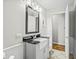 Updated bathroom with a pedestal sink, dark vanity, and modern mirror at 387 W Roszell Dr, Nineveh, IN 46164