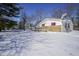 Side view of a white house with stone accents and snowy yard at 4201 Westbourne Dr, Indianapolis, IN 46205