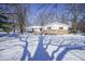White house with stone accents, snow-covered yard, and tree shadows at 4201 Westbourne Dr, Indianapolis, IN 46205