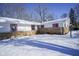 Front view of a ranch house with snowy yard and stone exterior at 4201 Westbourne Dr, Indianapolis, IN 46205