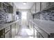 Modern kitchen with grey cabinets, granite counters, and tile backsplash at 4201 Westbourne Dr, Indianapolis, IN 46205