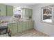 Renovated kitchen with granite counters and green cabinets at 555 N Sadlier Dr, Indianapolis, IN 46219