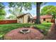 A backyard view features a fire pit and lush landscaping surrounding the home at 6072 Meridian St W Dr, Indianapolis, IN 46208