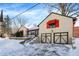 Snow-covered home exterior with a two-car garage and red accents at 6072 Meridian St W Dr, Indianapolis, IN 46208