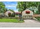 View of home featuring two-car garage, red awnings, and stone retaining wall at 6072 Meridian St W Dr, Indianapolis, IN 46208