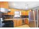 Kitchen with wood cabinets, stainless steel appliances, and tile flooring at 6072 Meridian St W Dr, Indianapolis, IN 46208