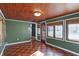 Bright sunroom with green walls, wood floors and wood ceiling at 6072 Meridian St W Dr, Indianapolis, IN 46208