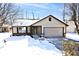 Beige house with brown accents, attached garage, and snow-covered yard at 6338 Cooper Pointe Dr, Indianapolis, IN 46268