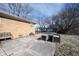 Brick home featuring a concrete patio, planting beds, and a chain-link fence enclosing the yard at 7201 E 71St St, Indianapolis, IN 46256