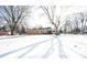 Snow covered yard with a brick ranch house in the background at 7201 E 71St St, Indianapolis, IN 46256