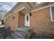 Close-up of a home's entrance featuring a decorative front door, brick facade, and concrete steps at 7201 E 71St St, Indianapolis, IN 46256