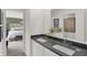 Bathroom view to a the bedroom featuring double vanity with stone countertops at 11614 Hartwell St, Indianapolis, IN 46235