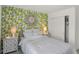 Comfortable bedroom features a floral accent wall, bedside tables, and ample lighting for a cozy ambiance at 11614 Hartwell St, Indianapolis, IN 46235