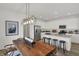 Well-lit kitchen with white cabinetry, stainless steel appliances, an island, and an adjacent wood dining table at 11614 Hartwell St, Indianapolis, IN 46235
