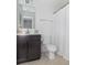 Clean bathroom with dark vanity, white toilet, and shower/tub at 1226 Arlington Dr, Greenfield, IN 46140