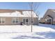 Rear view of townhouse with snow covered yard and tree at 1226 Arlington Dr, Greenfield, IN 46140