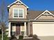 Charming home featuring a two-car garage, covered front porch, and well-manicured landscaping at 1226 Arlington Dr, Greenfield, IN 46140