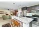 Open kitchen with island, stainless steel appliances, and views into living room at 1226 Arlington Dr, Greenfield, IN 46140