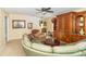 Spacious living room featuring a curved sofa, wooden cabinet, and ceiling fan at 1226 Arlington Dr, Greenfield, IN 46140