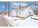 Side view of a white house with a snowy yard, showing a stop sign in the distance at 1363 & 1367 S Belmont Ave, Indianapolis, IN 46221