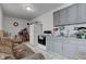 Small kitchen with gray cabinets, appliances, and a brown couch at 1363 & 1367 S Belmont Ave, Indianapolis, IN 46221