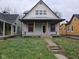 A charming yellow house with a gray porch and a small front yard at 1601 Spann Ave, Indianapolis, IN 46203