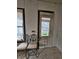 A room showing its dilapidated conditions with decaying walls, chairs, and a view of the home next door at 1601 Spann Ave, Indianapolis, IN 46203
