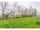 Expansive backyard featuring a lush green lawn and mature trees offering shade and privacy at 1681 Copeland Farms Dr, Greenfield, IN 46140