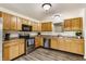 Well-lit kitchen features stainless steel appliances, wood cabinets, and wood-look floors at 1681 Copeland Farms Dr, Greenfield, IN 46140