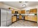 Well-lit kitchen features stainless steel appliances, wood cabinets, and wood-look floors at 1681 Copeland Farms Dr, Greenfield, IN 46140