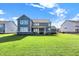 Large, newly seeded backyard with a spacious two-story house and clear blue skies at 19452 Lewis Cir, Westfield, IN 46074