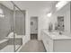 Bathroom featuring double vanity, glass shower, tile floor, and a glimpse of a walk-in closet at 19452 Lewis Cir, Westfield, IN 46074