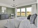 This bedroom features a large window with an exterior view, a gray dresser, and modern chandelier at 19452 Lewis Cir, Westfield, IN 46074