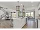 Modern kitchen island with stainless steel appliances and stylish lighting fixtures adjacent to the dining room at 19452 Lewis Cir, Westfield, IN 46074