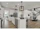 Bright open kitchen with an island, stainless appliances, stylish lighting, and wood flooring at 19452 Lewis Cir, Westfield, IN 46074