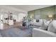 Open-concept living room with modern furniture, neutral tones, and views of the kitchen and dining areas at 19452 Lewis Cir, Westfield, IN 46074
