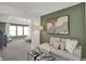 Cozy living room with a soft green accent wall and a view to a sun-drenched seating area at 19452 Lewis Cir, Westfield, IN 46074